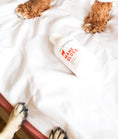 Load image into Gallery viewer, dog shampoo bottle on bed with dog paws