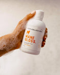 Load image into Gallery viewer, beautiful hand with subtle pink painted nails holding dog shampoo with bubbles 
