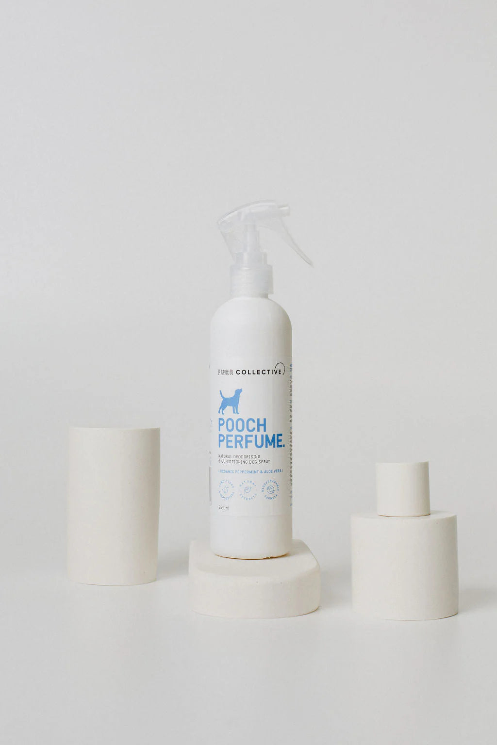 white dog perfume bottle in a clean white styled setting with blue writing 