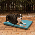 Load image into Gallery viewer, Border collie lying on a peacock blue Huntlea cooling dog mat on a patio
